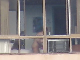 Mature woman naked in the window